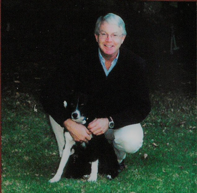 Rob Linn sitting down with a black and white dog.