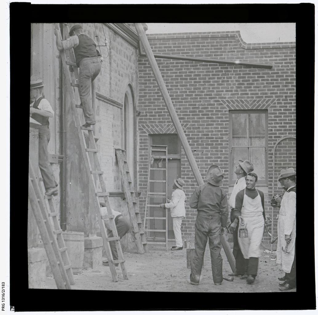 Church working bee shows men on ladders and other helpers
