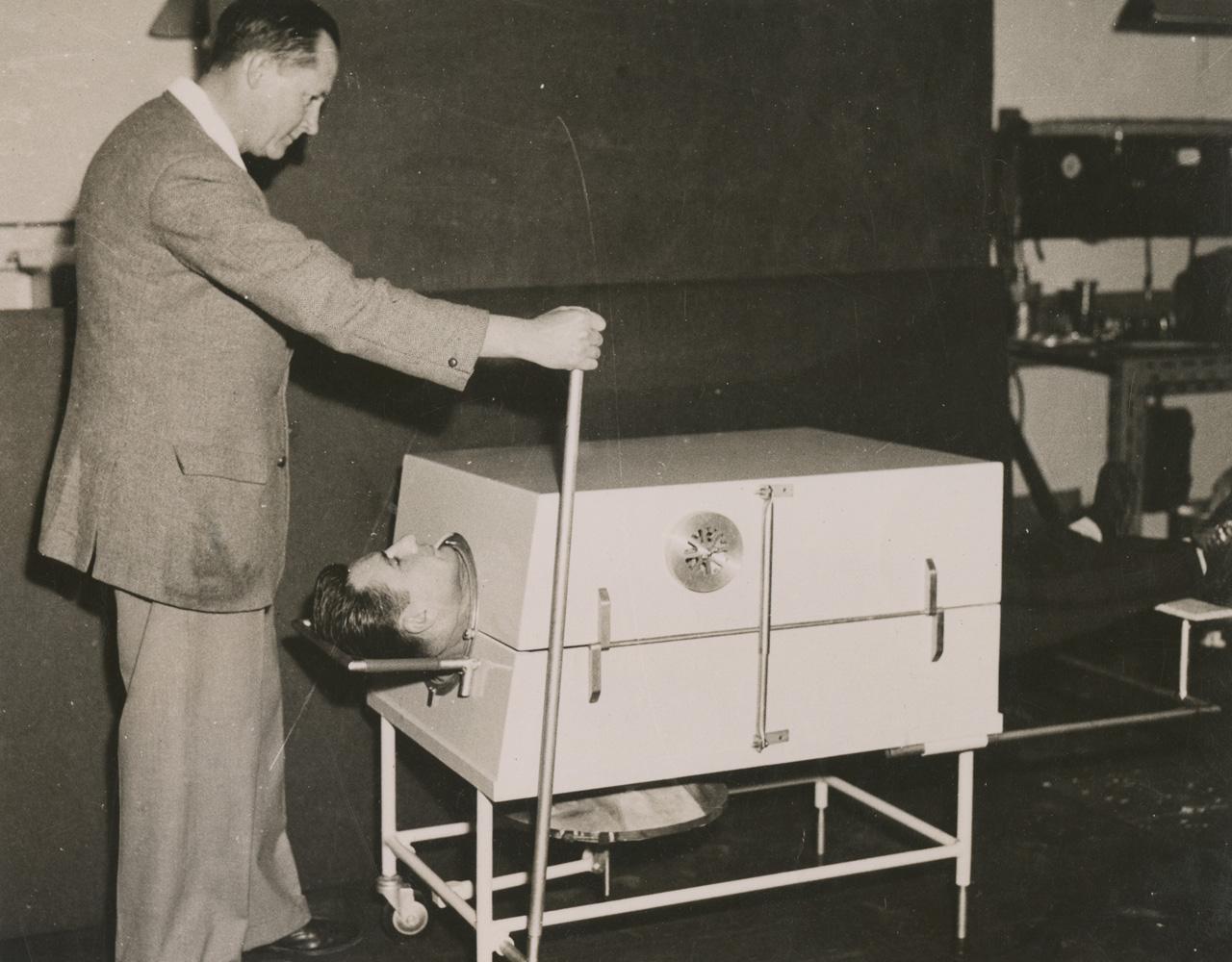 Donald Both demonstration the portable iron lung. SLSA: PRG 1776/2/20