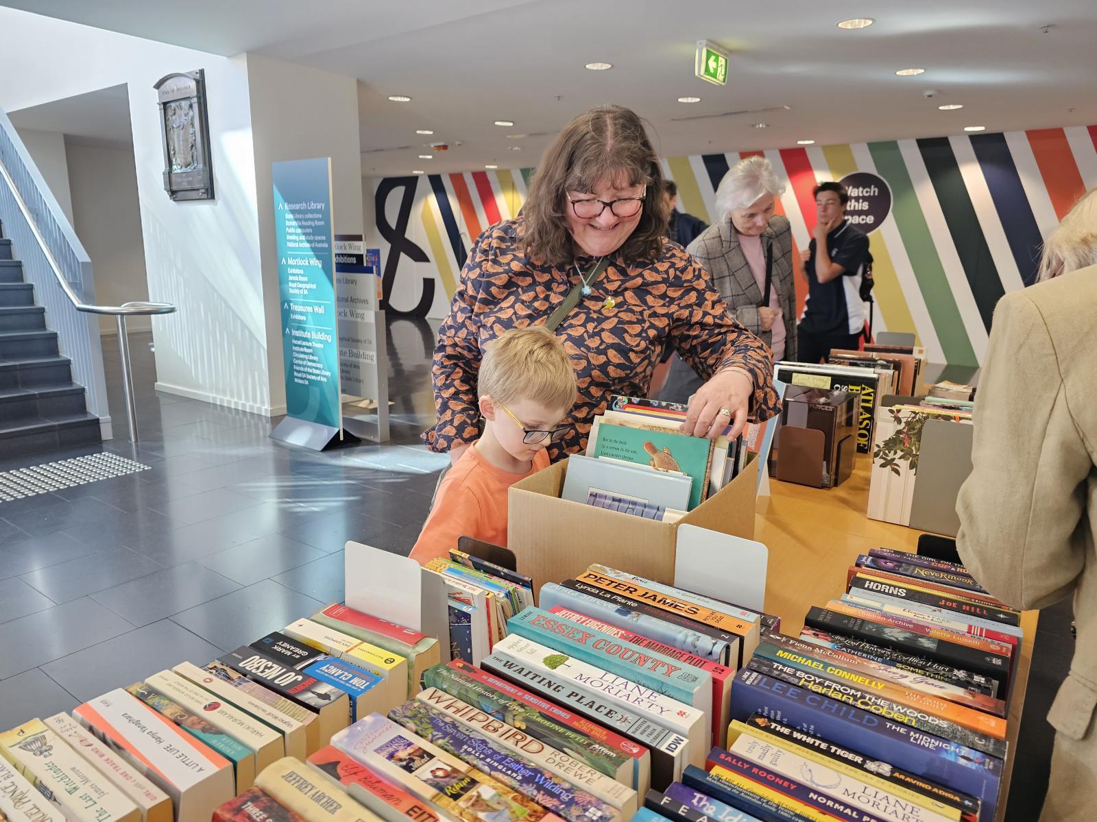 Lady and child looking at books on a bookstall
