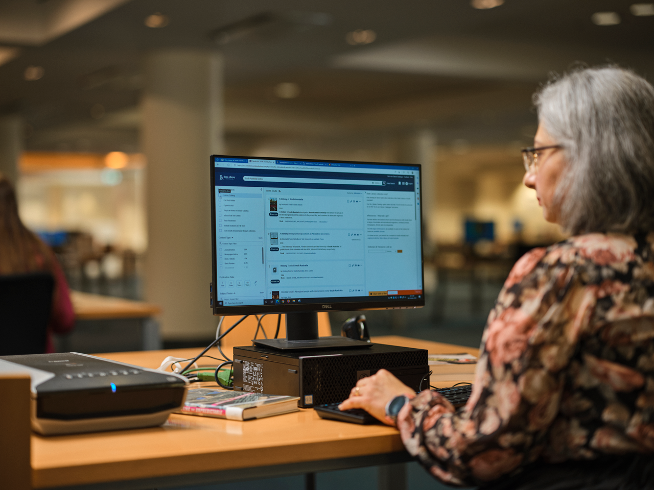 Lady searching a library catalogue on a computer