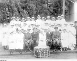 Women members of the Burra Ladies Brass Band sitting and standing with two army officers and two men in civilian dress on 'Violet Day' in South Australia. SLSA PRG 280/1/26/188