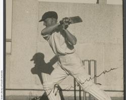 Photograph of Don Bradman in Photograph of Don Bradman in front of a wicket in a walled area, completing a drive, 1936. SLSA: B 68559f