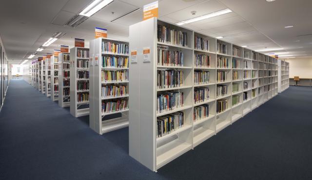 Rows of library shelves with books on them.