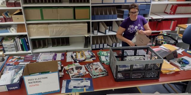 Lady sorting election promotional material on a desk