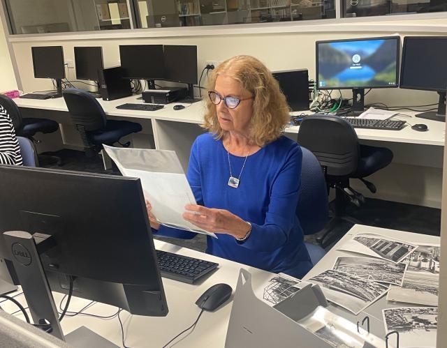 Judy Darwin examining Holden photograph in 2023.