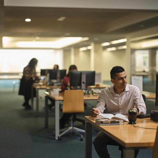Man sitting at a computer in a library