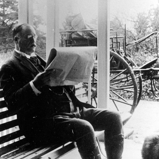 Walter Reynell reading a newspaper, 1906. SLSA: B58424