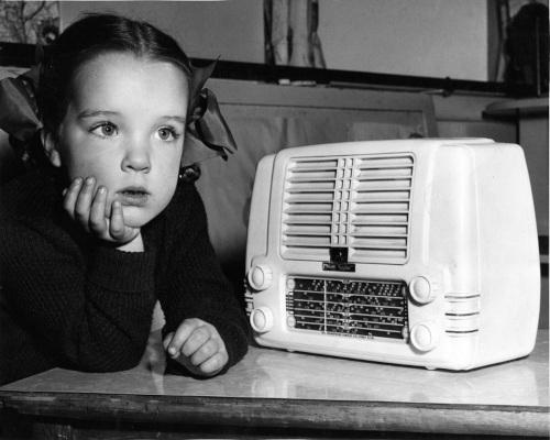 Child listening to a Little Nipper radio, 1950s. ABC Reference ID: abc.net.au/photo/DP001562