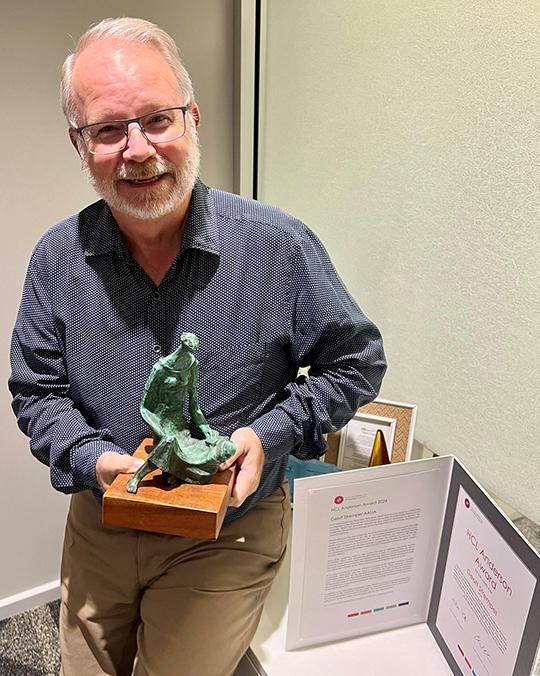 Geoff Strempel holding his award