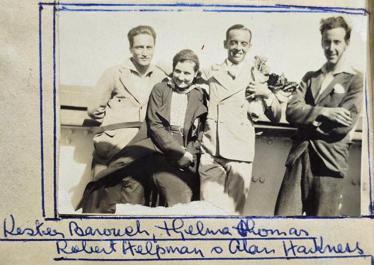 three men and one woman standing outdoors in relaxed holiday poses
