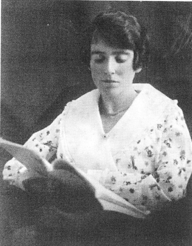 Young woman seated, reading